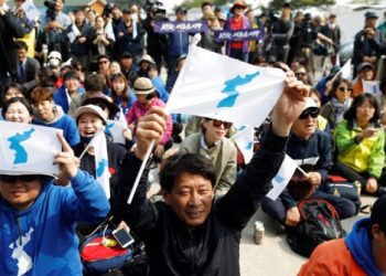 People hold the Korean unification flag during the inter-Korean summit, near the demilitarized zone separating the two Koreas, in Paju, South Korea, April 27, 2018.  REUTERS/Kim Hong-ji - RC152CA1E600