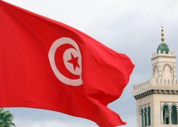 Red flag, clouds and minaret in Tunisia