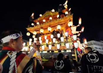 In this Tuesday, Dec. 3, 2019, photo, a man films a lantern-covered float going to the town central square during the Chichibu Night Festival in Chichibu, north of Tokyo, Japan. Moving six towering floats up a hill and into the town center is the culminating moment of a Shinto festival that has evolved from a harvest thanksgiving into a once-a-year meeting between two local gods. (AP Photo/Toru Hanai)