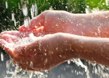 Hands catching clean falling water close up. Environmental concept.