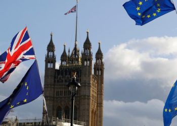 Union Jacks and EU flags fly over Britain's Parliament in London, Saturday, Oct. 19, 2019. In a major blow to British Prime Minister Boris Johnson, U.K. lawmakers voted Saturday to postpone a decision on whether to back his Brexit deal with the European Union, throwing a wrench into government plans to leave the bloc at the end of this month. (AP Photo/Kirsty Wigglesworth)