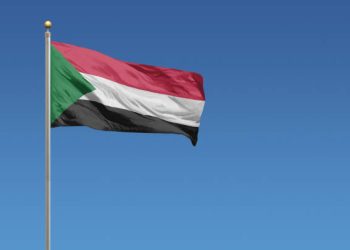 Flag of Sudan in front of a clear blue sky
