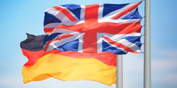 The British and German flags against the background of the blue sky